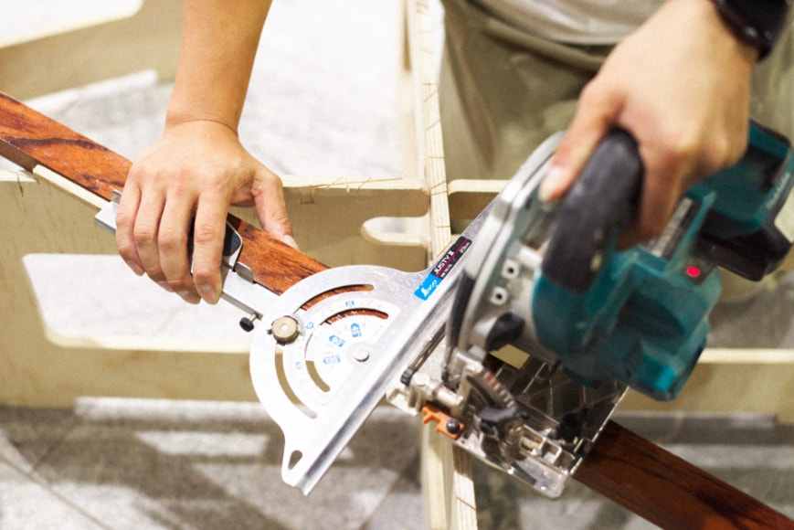 電動のノコギリで作業中の画像
